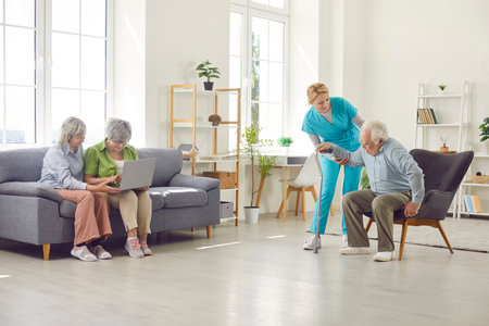 Retirement home room with skilled nurse and senior residents, nursing care service for old people, elder patients under supervising, gerontological guiding, comfortable living space for special needsの写真素材