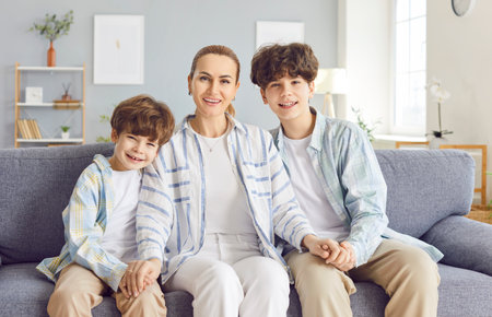 Loving mother, caring woman with little and teen son portrait, enjoy time together at home on...