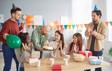 Happy birthday holiday with cake celebration, friendly enjoyable group, diverse friends party together for special event, smiling people gathering making fun, enjoy time, wishing great happiness, joyの写真素材