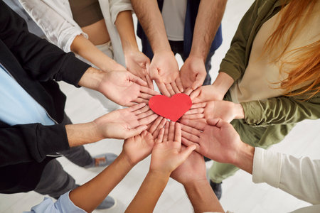 Group hand close up red heart holding together, grateful hopeful feeling pleased thankful, sincere expressing heartfelt love appreciation, gratitude honesty, team volunteering offering heart checkupの写真素材