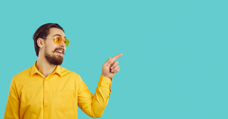 Wide banner shot of smiling eccentric man in sunglasses isolated on blue studio background. Funny...