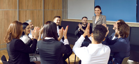 Young womans work being greatly appreciated. Group of happy cheerful positive respectful employees...