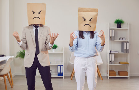 Conflict in office, unhappy paper bag head negative emotion face, coworkers, couple family, feeling sad in emotionalの写真素材