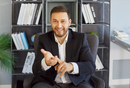 Portrait of happy confident employee wearing formal suit looking at camera having online video call...