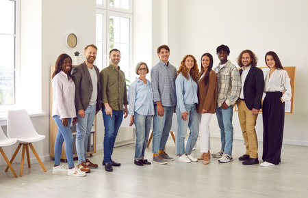 Full length portrait of young happy group of business multiethnic people men and women looking at...