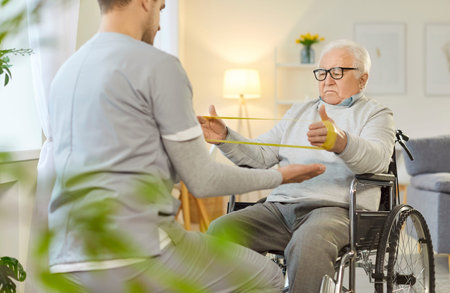 Doctor or nurse leading a rehabilitation session with an senior patient in a wheelchair, focusing on...