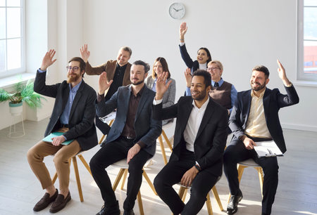 People team meeting during training workshop raise hands. Business audience cast a vote on key...