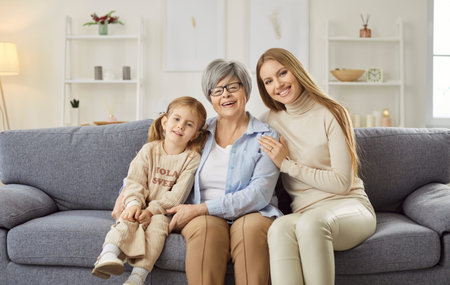Kind loving three generations, affectionate young granddaughter and elderly grandma close hug,...