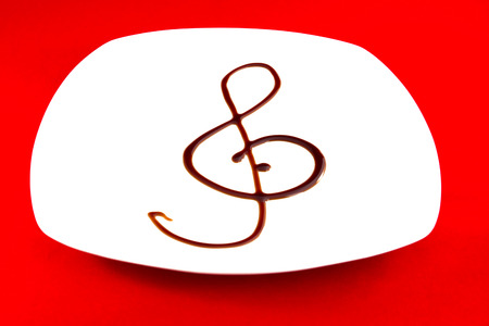 Treble clef made ââwith balsamic vinegar on white plateの写真素材
