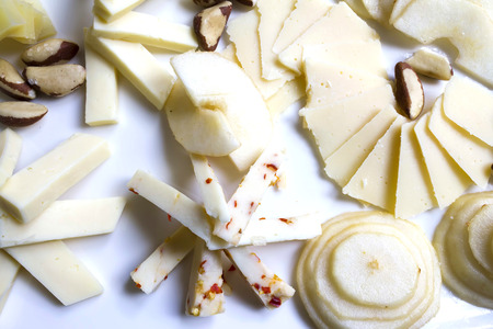 Variety of cheeses on dish with pecans and pears
