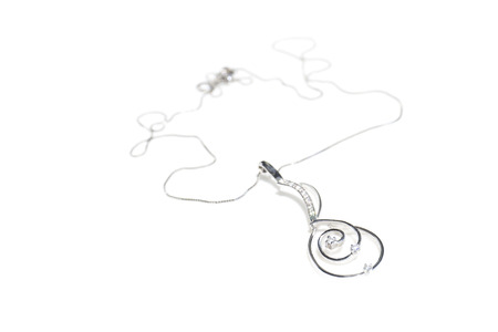 White gold necklace with diamond pendant on a white backgroundの写真素材