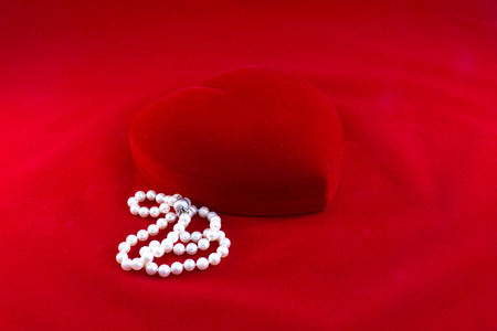 A necklace of pearls in a heart shaped red boxの写真素材