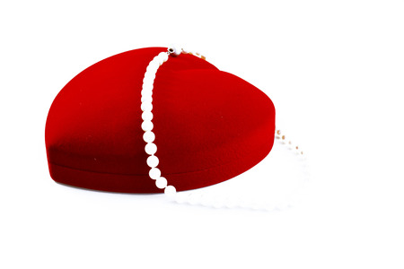 A necklace of pearls in a heart shaped red boxの写真素材
