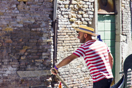 VENICE, ITALY, August 10, 2011: Gondolier on a gondola on the Grand Canal in Venice. Gondola's are a major mode of touristic transport in Venice, Italy.のeditorial素材