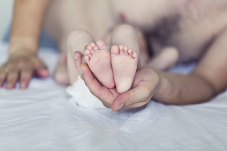 Baby feet cupped into father hands
