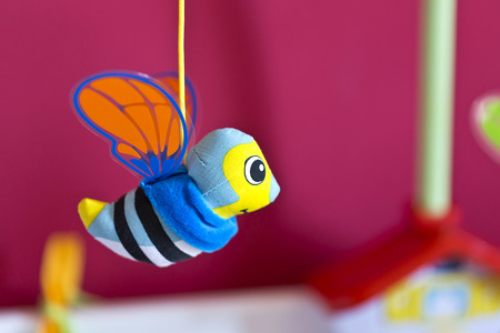 Little bee hanging above baby bed. Toys for babiesの写真素材
