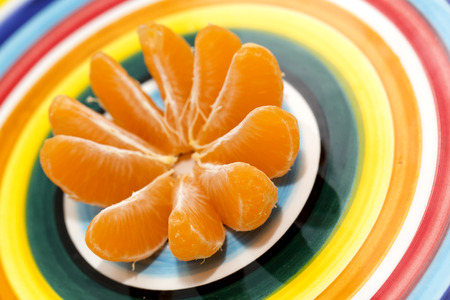 Clementine orange isolated on a multicolored dishの写真素材