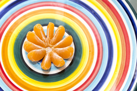 Clementine orange isolated on a multicolored dish
