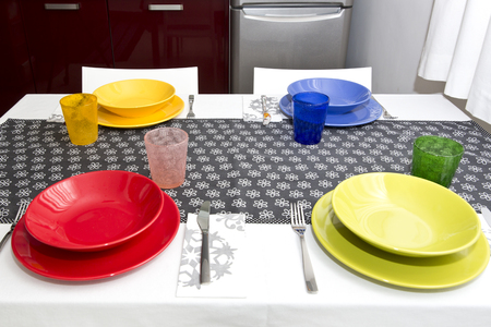 Table set with colorful dishes in the home kitchenの写真素材