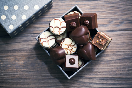 Assorted chocolate pralines on a wooden background
