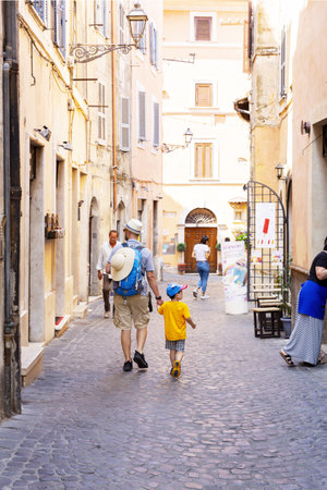 Asisisi, Umbria, July 16, 2019: Dad and son, tourists, stroll through the streets of Assisi, Umbria, Italyのeditorial素材