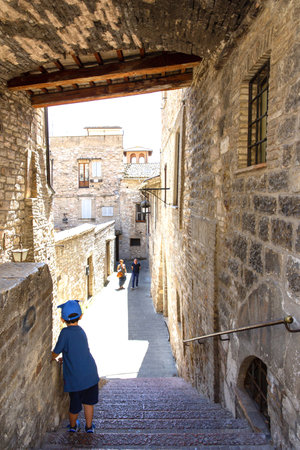 Child walks through the streets of the historic center of Assisi, Umbria, Italyのeditorial素材