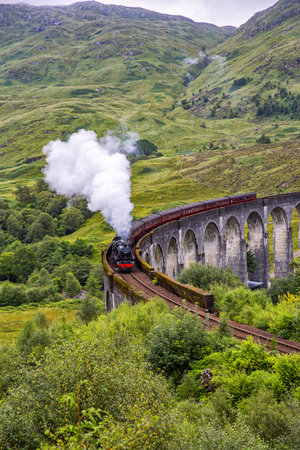 Glenfinnan railway viaduct in Scotland with the Jacobite steam train passing by, Scotland