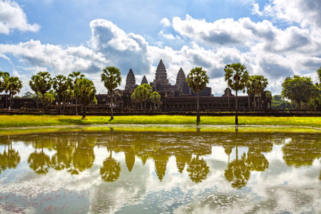 angkor wat, cambodia, temple, reflection, water, ancient, khmer, architecture, asia, asian, southeast asia, travel, tourism, landmark, historical, sky, clouds, trees, landscape, religion, heritage, monument, outdoors, day, sunny, iconic, towers, moat, world heritage, unesco, serene, peaceful, history, culture, art, stone, ruins, nature, scenicの写真素材
