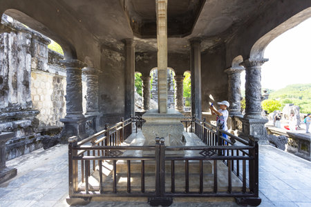 HUE, VIETNAM, August 16, 2024: A visitor looks at the large stele inside the pavilion at the Tomb of Khai Dinh in Hue, Vietnamの写真素材