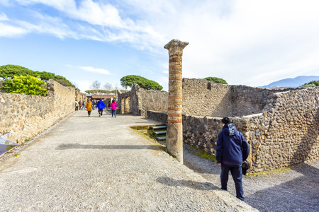 POMPEII, ITALY 2025, March 02: Tourists explore the well-preserved ruins of Pompeii, the ancient Roman city destroyed by the eruption of Mount Vesuviusの写真素材