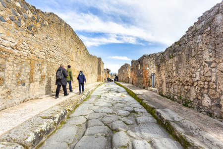 POMPEII, ITALY 2025, March 02: Tourists explore the well-preserved ruins of Pompeii, the ancient Roman city destroyed by the eruption of Mount Vesuviusの写真素材