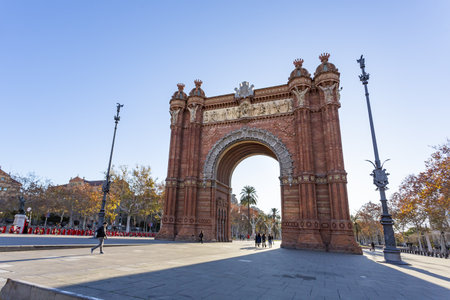 The Arc de Triomf in Barcelona is a grand triumphal arch, built in red brick, serving as a gateway to the city's historic center and a symbol of Catalan heritage.の写真素材