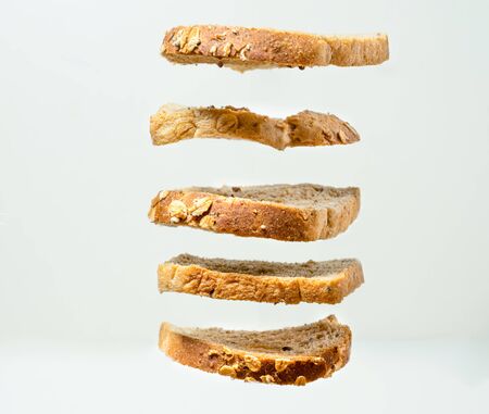 Close up of fresh toasts with nuts fly on the air isolated white background