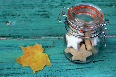 Autumn cookies in a retro glass jar and leaf on a blue wooden backgroundの写真素材