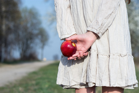 girl with a red apple in hand on the roadの写真素材