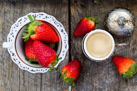 fresh organic strawberries and traditional turkish coffee on wooden backgroundの写真素材