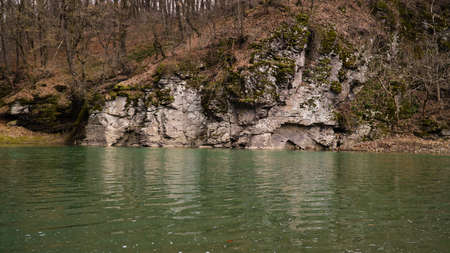 Landscape with a rocky shore of a lake in the forest.