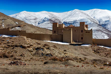 View of castle in Imilchil in front of snowy mountains, Moroccoのeditorial素材