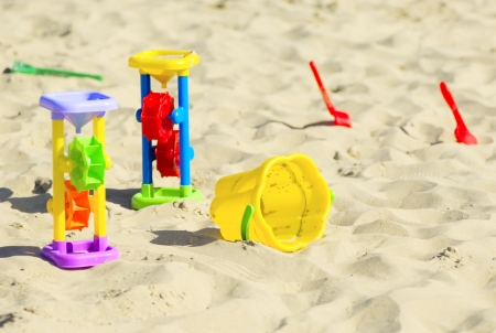 Children`s toys for sand and sunblock lotion at the beach. Summer vacations conceptの写真素材