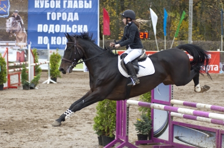 PODOLSK - OCTOBER 6  K Kovaleva ride on horse on tournament show jumping of major of city Podolsk on October 6, Podolsk, Russiaのeditorial素材