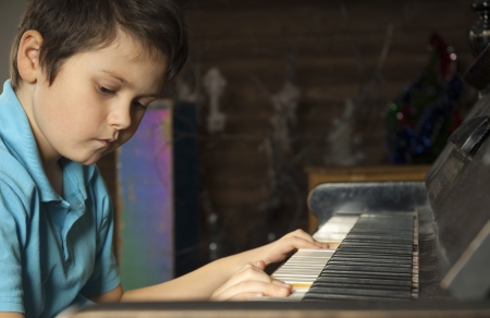 Studio shot of boy playing the piano. Serious face of little composerの写真素材