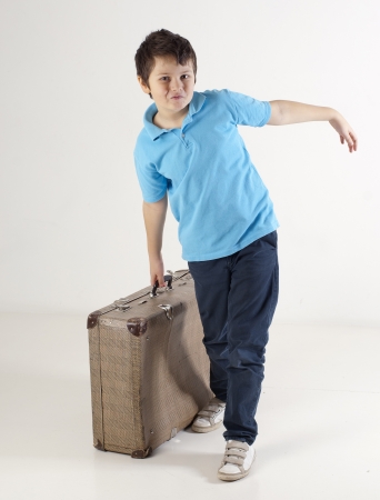 Studio shot of little boy with big suitcaseの写真素材