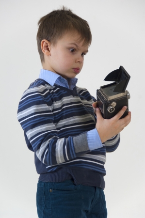 Boy with retro photocamera in studioの写真素材