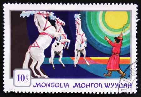 MOSCOW, RUSSIA - APRIL 2, 2017: A post stamp printed in Mongolia shows a trained horse rearing for a circus trainer, series Mongolian circuses, circa 1974のeditorial素材