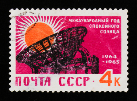 MOSCOW, RUSSIA - JUNE 26, 2017: A stamp printed in USSR (Russia) shows sun and radio telescope radar, international quiet sun year 1964-1965, circa 1964のeditorial素材