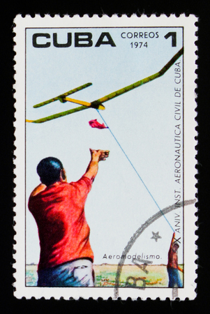 MOSCOW, RUSSIA - SEPTEMBER 3, 2017: A stamp printed in Cuba shows Man and Model Aircraft , 10 anniversary of the Institute of Civil Aviation, circa 1974のeditorial素材
