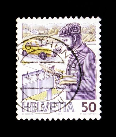 MOSCOW, RUSSIA - SEPTEMBER 3, 2017: A stamp printed in Switzerland shows Postman, Post Delivery serie, circa 1988のeditorial素材