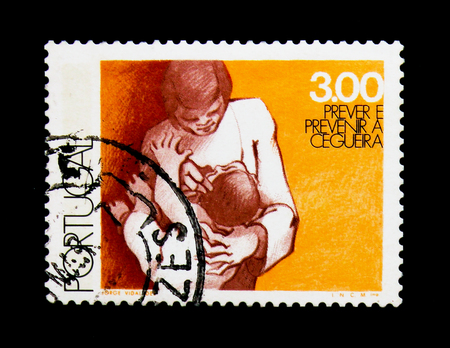 MOSCOW, RUSSIA - NOVEMBER 24, 2017: A stamp printed in Portugal shows Mother examining Child's Eyes, World Health Day - Prevent Blindness serie, circa 1976のeditorial素材