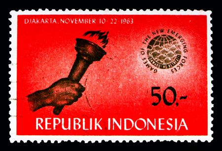 MOSCOW, RUSSIA - MAY 13, 2018: A stamp printed in Indonesia shows Hand with torch, Games of the New Emerging Forces serie, circa 1963のeditorial素材