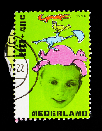 MOSCOW, RUSSIA - MAY 13, 2018: A stamp printed in Netherlands shows Boy with animals, Children Stamps - Year of the Disabled serie, circa 1996のeditorial素材